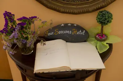 a table with an open book and flowers on it at Four Seasons Hotel in Athens