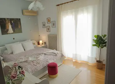 a bedroom with a bed and a window with a plant at Chalandri Bloom Residence 2BR Sleeps 6 in Athens