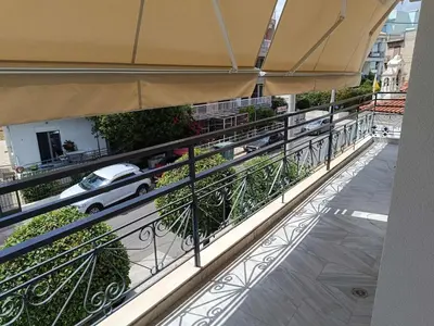 a balcony with an umbrella and a car on a street at Chalandri Bloom Residence 2BR Sleeps 6 in Athens
