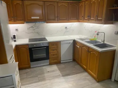 a kitchen with wooden cabinets and a sink at Chalandri Bloom Residence 2BR Sleeps 6 in Athens