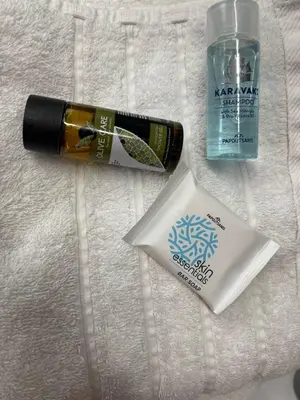 a bottle of mascara and a bottle of water on a towel at Central, Quiet & Comfortable Apartment in Athens