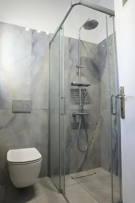 a bathroom with a glass shower with a toilet at Serene & Stylish apt by GHH in Athens