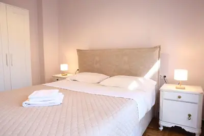 a bedroom with a white bed with two night stands at Serene & Stylish apt by GHH in Athens
