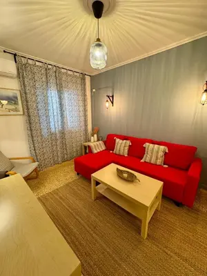 a living room with a red couch and a coffee table at Mosaic Apartment in Athens