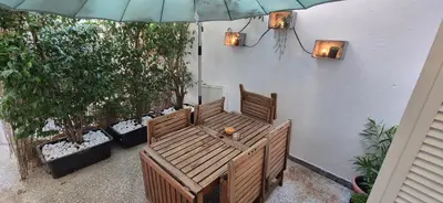 a patio with two benches and an umbrella at Mosaic Apartment in Athens