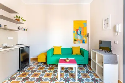 a living room with a green couch and a table at B2 Porto Living in Piraeus