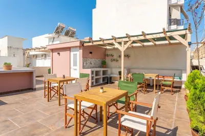 a patio with tables and chairs and a pergola at B2 Porto Living in Piraeus