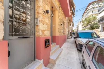 a building with a door and a car parked on a street at B2 Porto Living in Piraeus