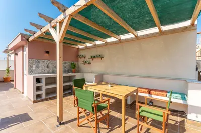 a patio with a wooden table and chairs at B2 Porto Living in Piraeus