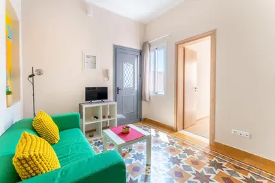 a living room with a green couch and a table at B2 Porto Living in Piraeus