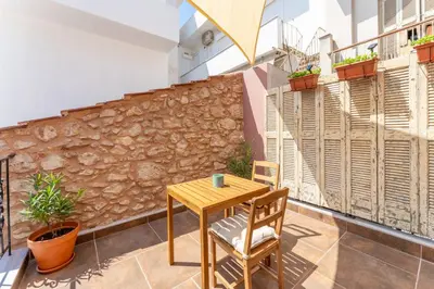 a table and chair in a room with a stone wall at B2 Porto Living in Piraeus