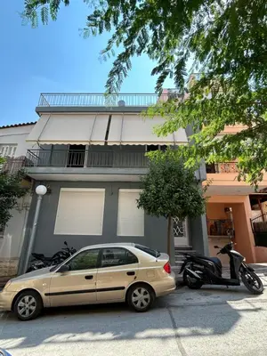 a car parked in front of a building with a scooter at Μοντέρνο διαμέρισμα στη Δάφνη in Athens