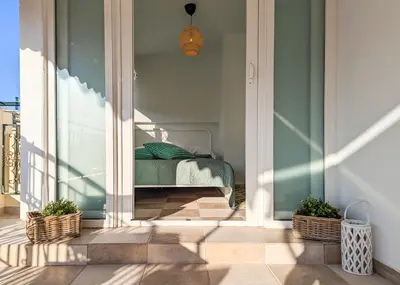 a room with a bed on a balcony with two plants at Penthouse 4BD apt near Acropolis and metro in Athens