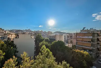 a view of a city with the sun in the sky at Penthouse 4BD apt near Acropolis and metro in Athens
