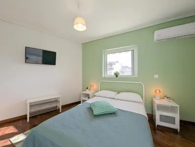 a green bedroom with a bed and a window at Penthouse 4BD apt near Acropolis and metro in Athens