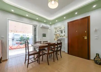 a kitchen and dining room with a wooden table and chairs at Penthouse 4BD apt near Acropolis and metro in Athens