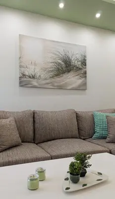 a living room with a couch and a painting on the wall at Penthouse 4BD apt near Acropolis and metro in Athens