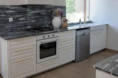 a kitchen with a stove and a sink at Comfortable Villa - 2min from the Beach in Porto Rafti