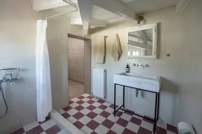 a bathroom with a sink and a checkered floor at Comfortable Villa - 2min from the Beach in Porto Rafti