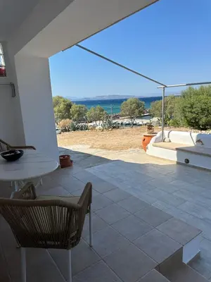 a patio with a table and chairs and a view at Orris Seaside in Vaia