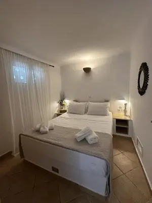 a bedroom with a large bed with towels on it at Orris Seaside in Vaia