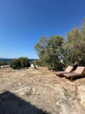 a pair of lounge chairs sitting on top of a field at Orris Seaside in Vaia