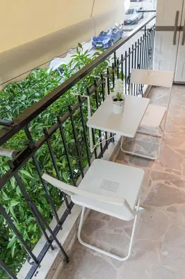 a white table and chairs on a balcony at Theonisxenia Luxury Apt at Metro M3 in Athens