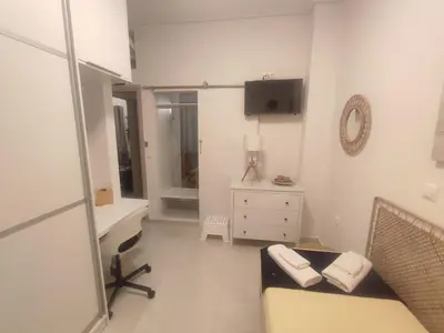a living room with a couch and a tv on the wall at Theonisxenia Luxury Apt at Metro M3 in Athens