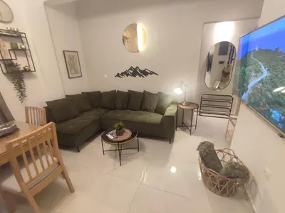 a living room with a couch and a flat screen tv at Theonisxenia Luxury Apt at Metro M3 in Athens