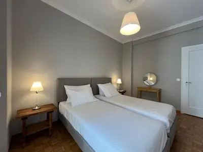 a bedroom with a large white bed with two lamps at Piraeus Pearl - Seaview Elegance in Piraeus