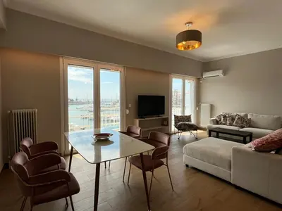 a living room with a couch and a table at Piraeus Pearl - Seaview Elegance in Piraeus