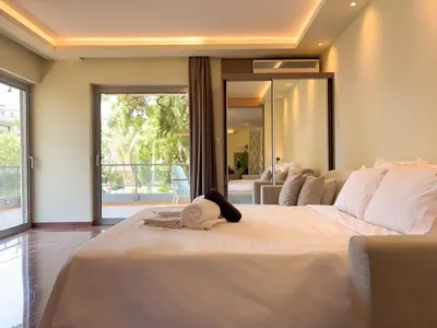 a large white bed in a room with a large window at Luxurious & Spacious Flat in Glyfada Center in Athens