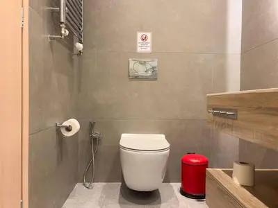 a bathroom with a toilet and a red trash can at Luxurious & Spacious Flat in Glyfada Center in Athens