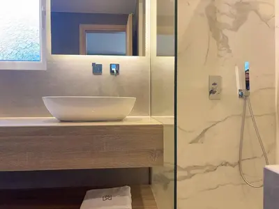 a bathroom with a sink and a glass shower at Luxurious & Spacious Flat in Glyfada Center in Athens