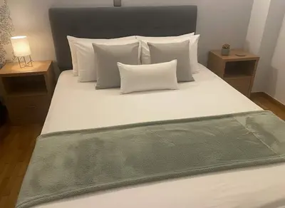 a large bed with a green blanket on it at Cozy City Hideaway in Zografou in Athens