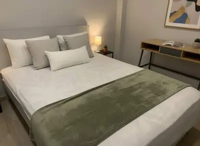 a bedroom with a large bed with white sheets and pillows at Cozy City Hideaway in Zografou in Athens