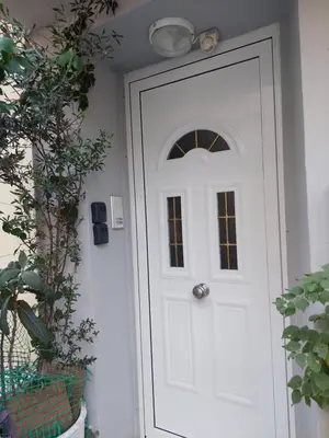 a white door with a window and a light above it at An's Piraeus port comfort apartment in Piraeus