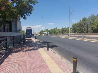 an empty street with a bus stop on the side of the road at An's Piraeus port comfort apartment in Piraeus