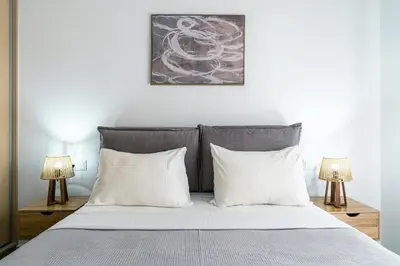 a bedroom with a bed with white pillows and two lamps at Family Comfort Meets Modern style in Athens in Athens