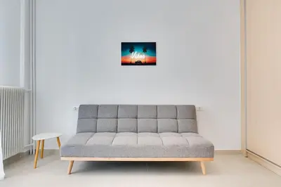a couch in a living room with a picture on the wall at Family Comfort Meets Modern style in Athens in Athens