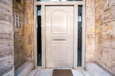 a white door in a brick building with a rug at Family Comfort Meets Modern style in Athens in Athens