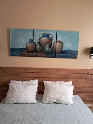 a bed with two pillows and three vases on the wall at Athenian Stay 301 By VPN in Athens