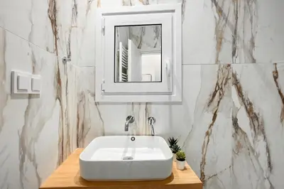 a bathroom with a white sink and a mirror at The Magnificent Exarchia Loft Apartments in Athens