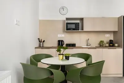 a kitchen with a table and green chairs at The Magnificent Exarchia Loft Apartments in Athens