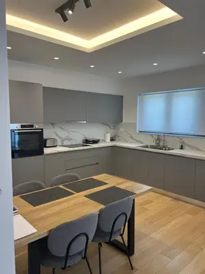 a kitchen with a table and chairs and a large screen at New apartment in Athens