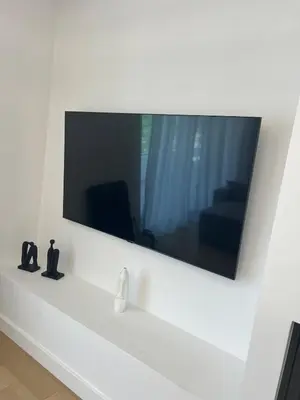 a large mirror on a white wall with a couch at New apartment in Athens