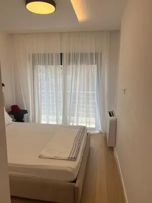 a bedroom with a bed and a window with white curtains at New apartment in Athens