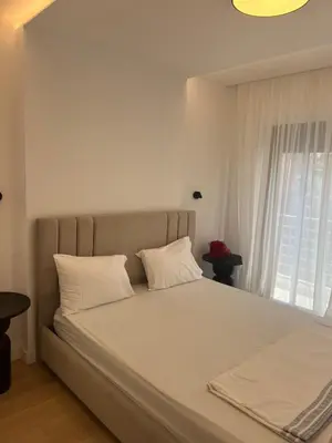 a bed with white pillows in a bedroom with a window at New apartment in Athens