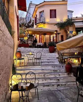 a set of stairs with tables and chairs in front of a building at Kalliopi Studio in Athens