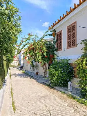 a street with a white house with red flowers at Kalliopi Studio in Athens